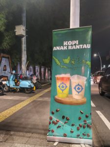Spanduk Kopi Anak Rantau terpasang di kawasan Kemang Selatan, tepat di depan Wisma Kemang. Kedai ini menawarkan menu favorit seperti Kopi Anak Rantau, Kopi Anak Punk, serta minuman nonkopi Epoch dengan jam ramai pengunjung mulai pukul 20.30 hingga 23.30 WIB.