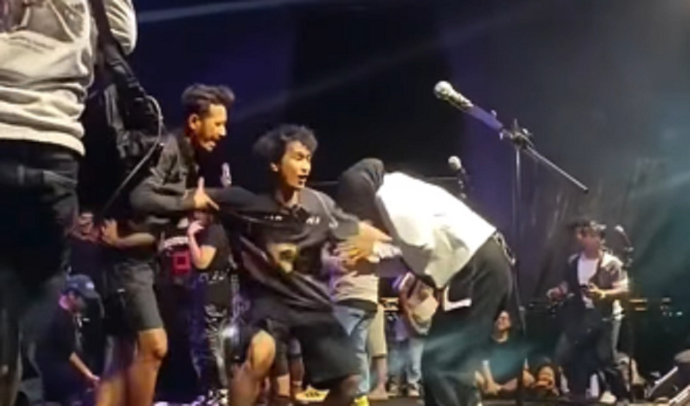 Keterangan foto: Bona (tengah) sedang memisahkan penonton yang berusaha memeluk dari Tantri Kotak. Dok/Instagram